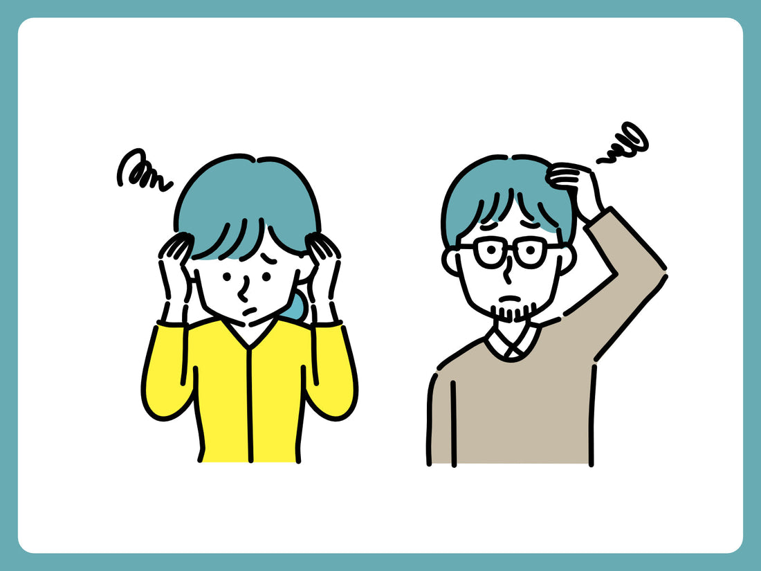 頭が重くこめかみを押さえながら休む女性の写真