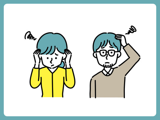 頭が重くこめかみを押さえながら休む女性の写真